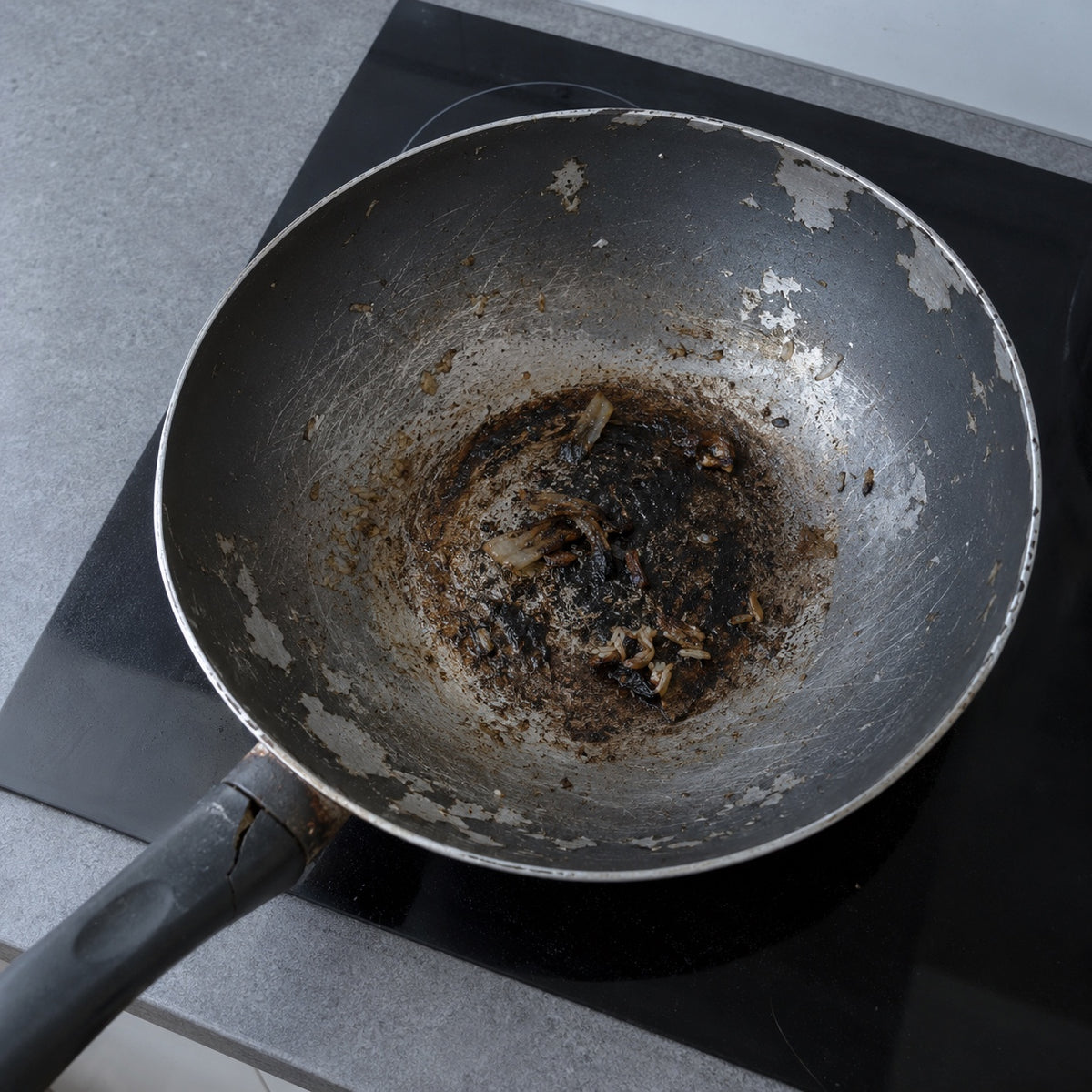 Wok classique abîmé, revêtement écaillé et aliments brûlés collés Image